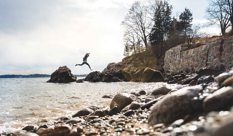 Leaping between rocks along a stone-walled coastline