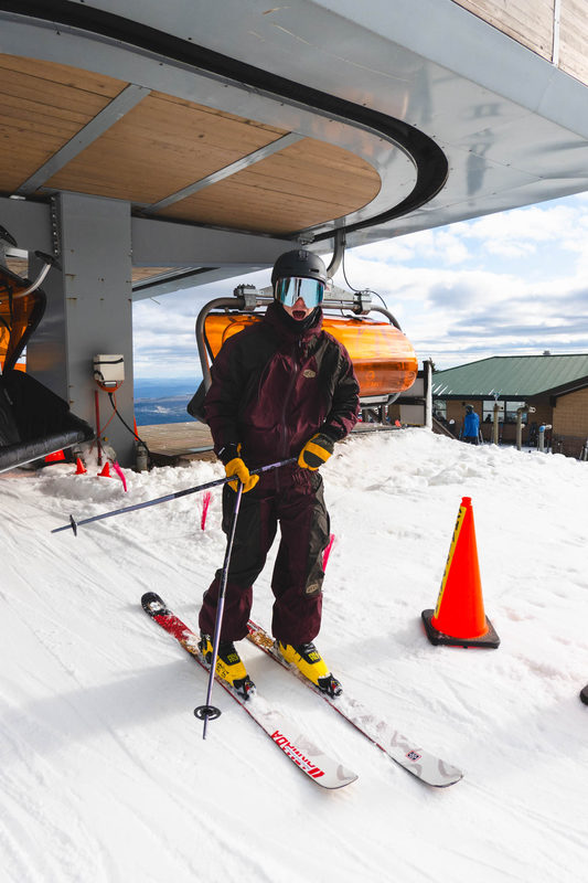 Skier posing at the top of a chairlift at Okemo Mountain