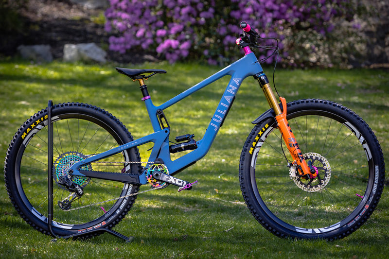 Blue and orange Juliana mountain bike on a repair stand in a yard