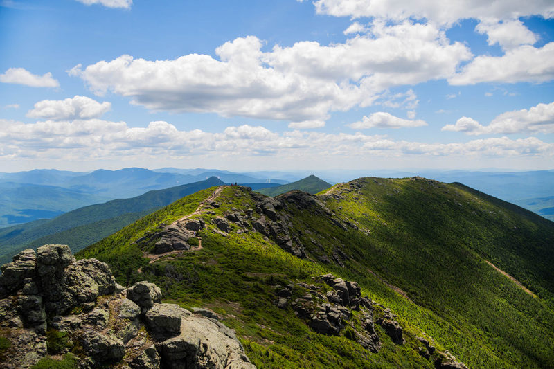 Hikers on the exposed Franconia Ridge Trail leading toward Mount Lafayette