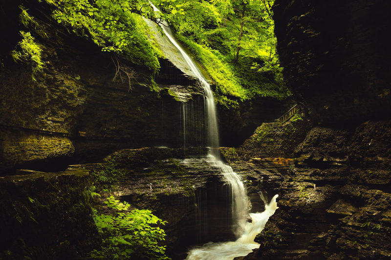 Tiered waterfall dropping through a moss-covered stone gorge in Watkins Glen